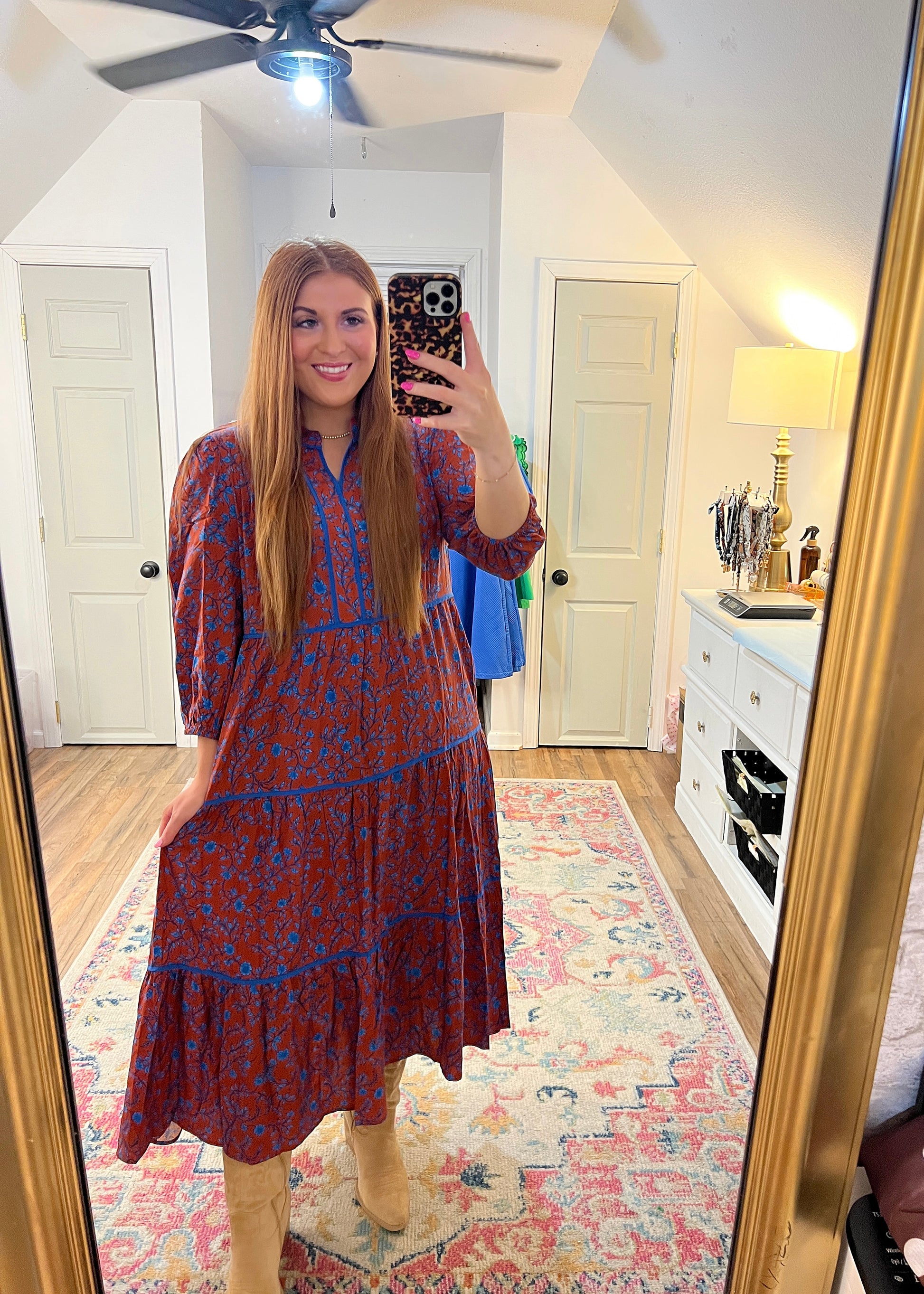 rust colored maxi dress with a blue floral design and trim detail, slight v neck 