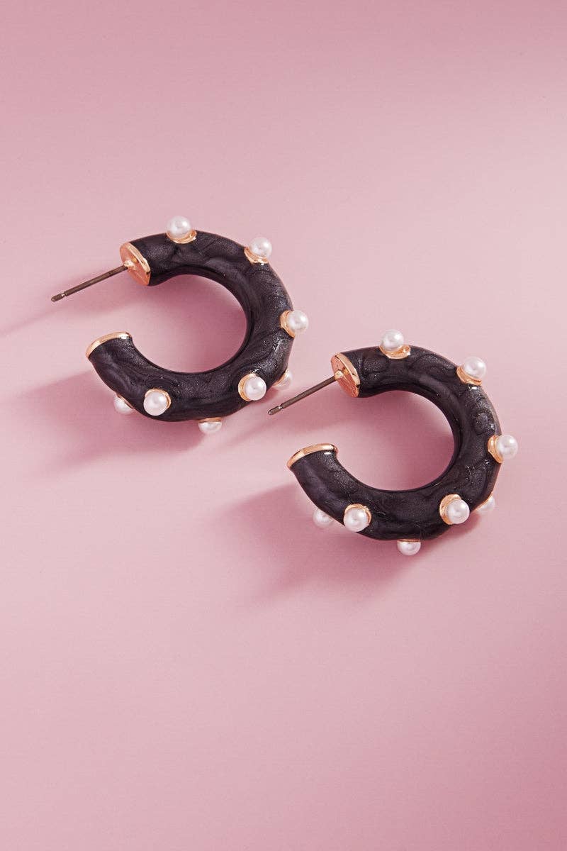 A pair of black hoop earrings with pearl detailing 