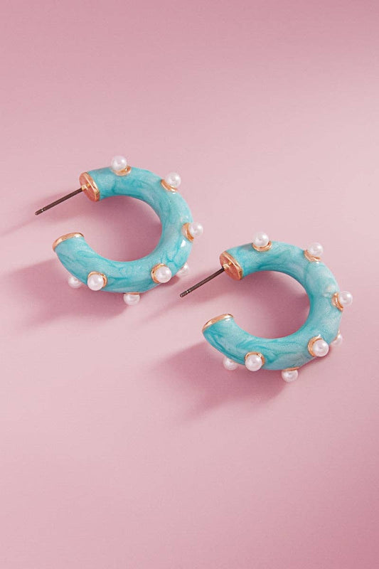 A pair of turquoise hoop earrings with pearl detailing 
