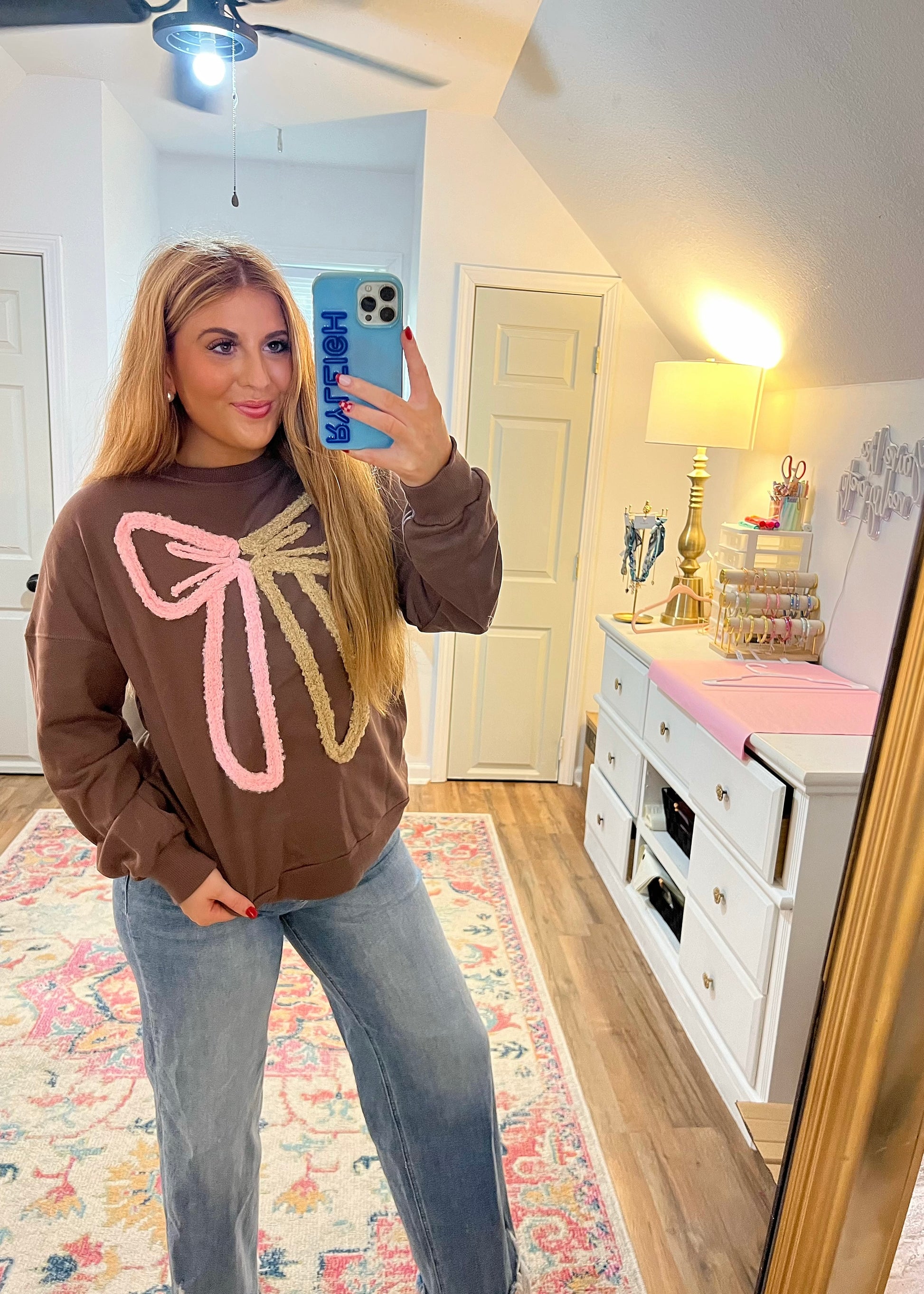 brown sweatshirt with pink and tan bow yarn detail 